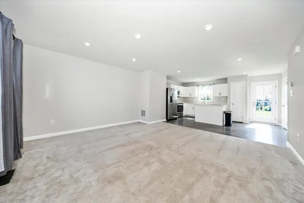 a living room with furniture and view of kitchen