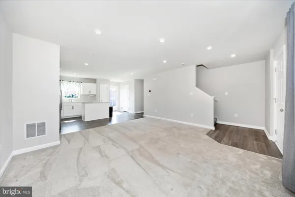 a view of a kitchen with a sink and cabinet a refrigerator a fireplace