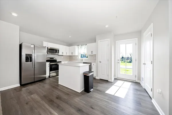 a large kitchen with stainless steel appliances kitchen island granite countertop a stove and a sink