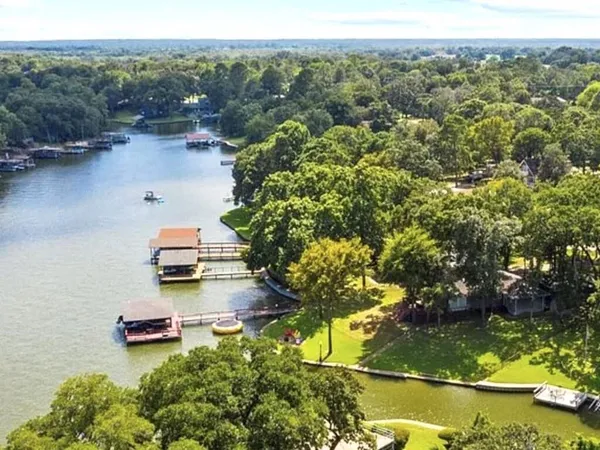 an aerial view of a house with a yard and lake view