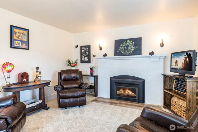 a living room with furniture a fireplace and a flat screen tv