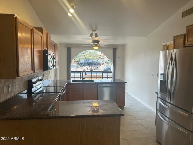 a kitchen with stainless steel appliances granite countertop a stove a sink and a microwave