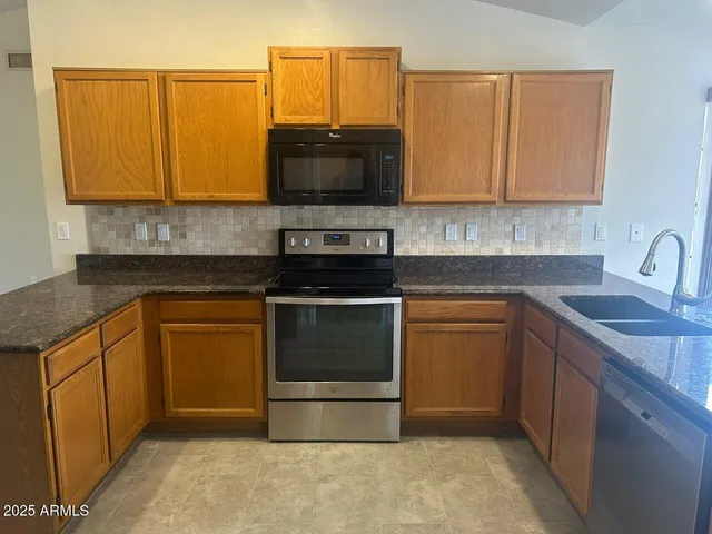a kitchen with stainless steel appliances granite countertop a refrigerator and a sink
