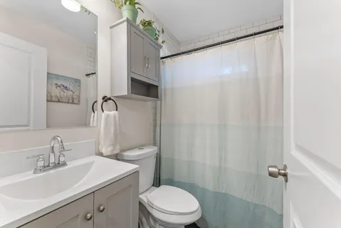 a bathroom with a sink a toilet and shower