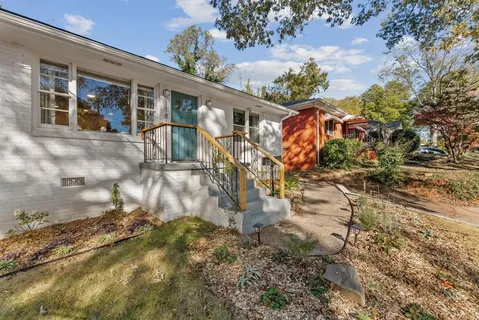 a backyard of a house with a yard and outdoor seating