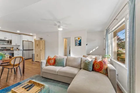 a living room with furniture and kitchen view