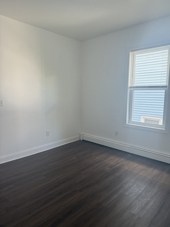 25 Highland Street, Unit 1L Revere, MA 02151 - Photo 9 of 11 a view of an empty room with wooden floor and a window