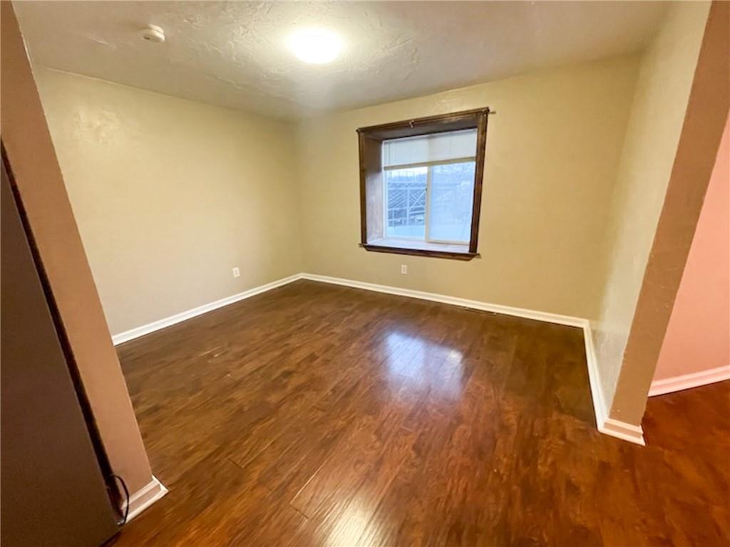 312 Jackson Avenue Vandergrift, PA 15690 - Photo 13 of 21 an empty room with wooden floor and windows