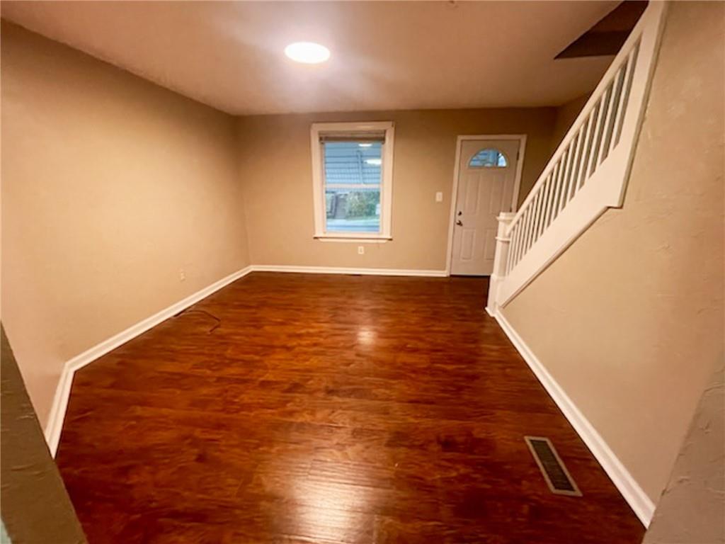 312 Jackson Avenue Vandergrift, PA 15690 - Photo 6 of 21 a view of an empty room with wooden floor and stairs