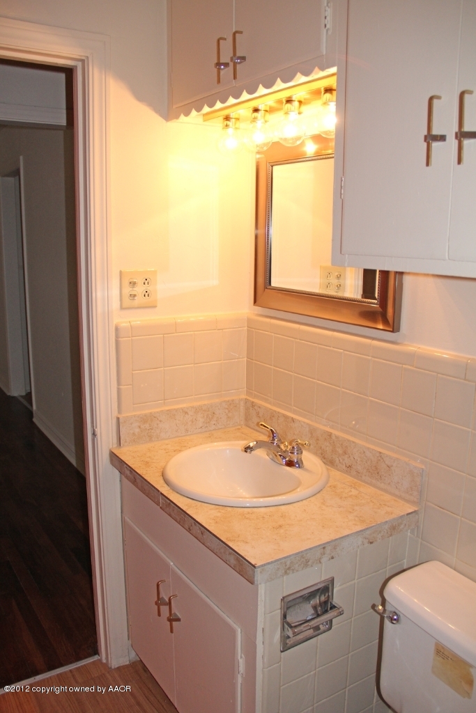 3604 South Hayden Street Amarillo, TX 79110 - Photo 15 of 21 a bathroom with a sink and a large mirror