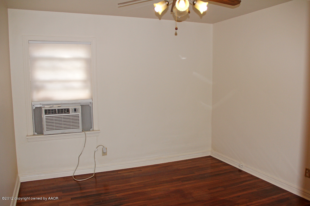 3604 South Hayden Street Amarillo, TX 79110 - Photo 17 of 21 a view of an empty room with wooden floor and a window