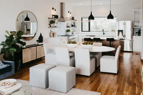 a living room with stainless steel appliances kitchen island granite countertop lots of white furniture