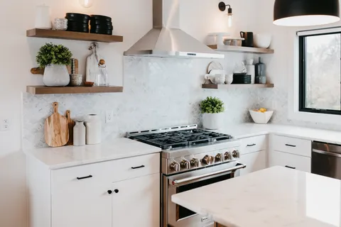 a kitchen with stainless steel appliances granite countertop a stove and white cabinets