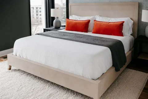 a room with a bed lamp and a potted plant