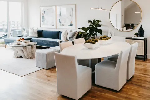 a living room with furniture a large window and wooden floor
