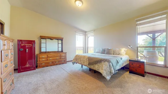a bedroom with a bed dresser and window