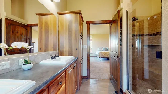 a en suite bathroom with a granite countertop sink and a mirror
