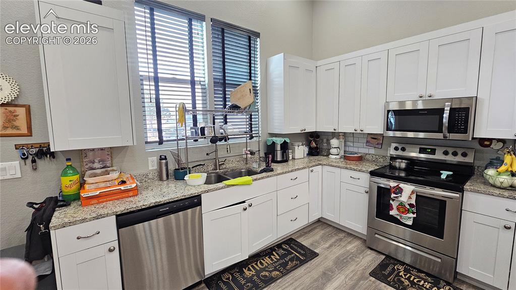 3835 Sengbeil Road Yoder, CO 80864 - Photo 14 of 48 a kitchen with stainless steel appliances a sink a stove cabinets and a window