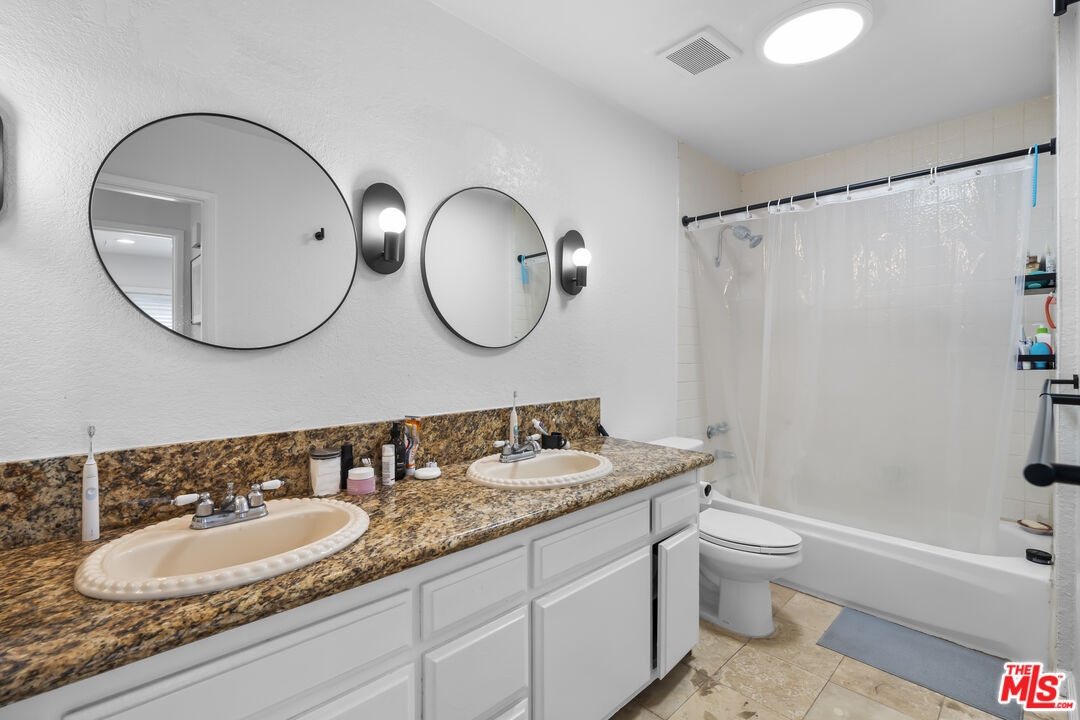 23 Buccaneer Street Marina del Rey, CA 90292 - Photo 18 of 39 a bathroom with a granite countertop sink and a mirror