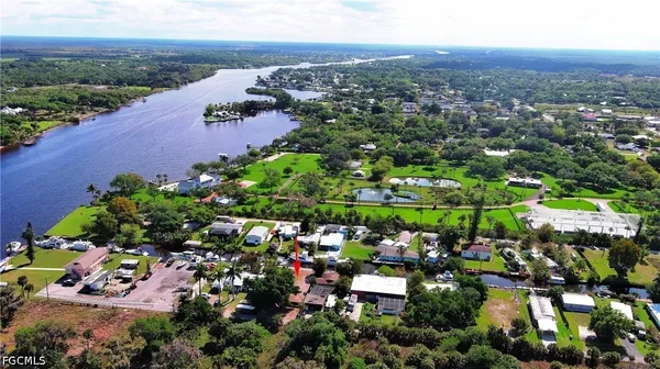 an aerial view of residential houses with outdoor space and trees