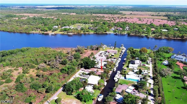 an aerial view of ocean and residential houses with outdoor space