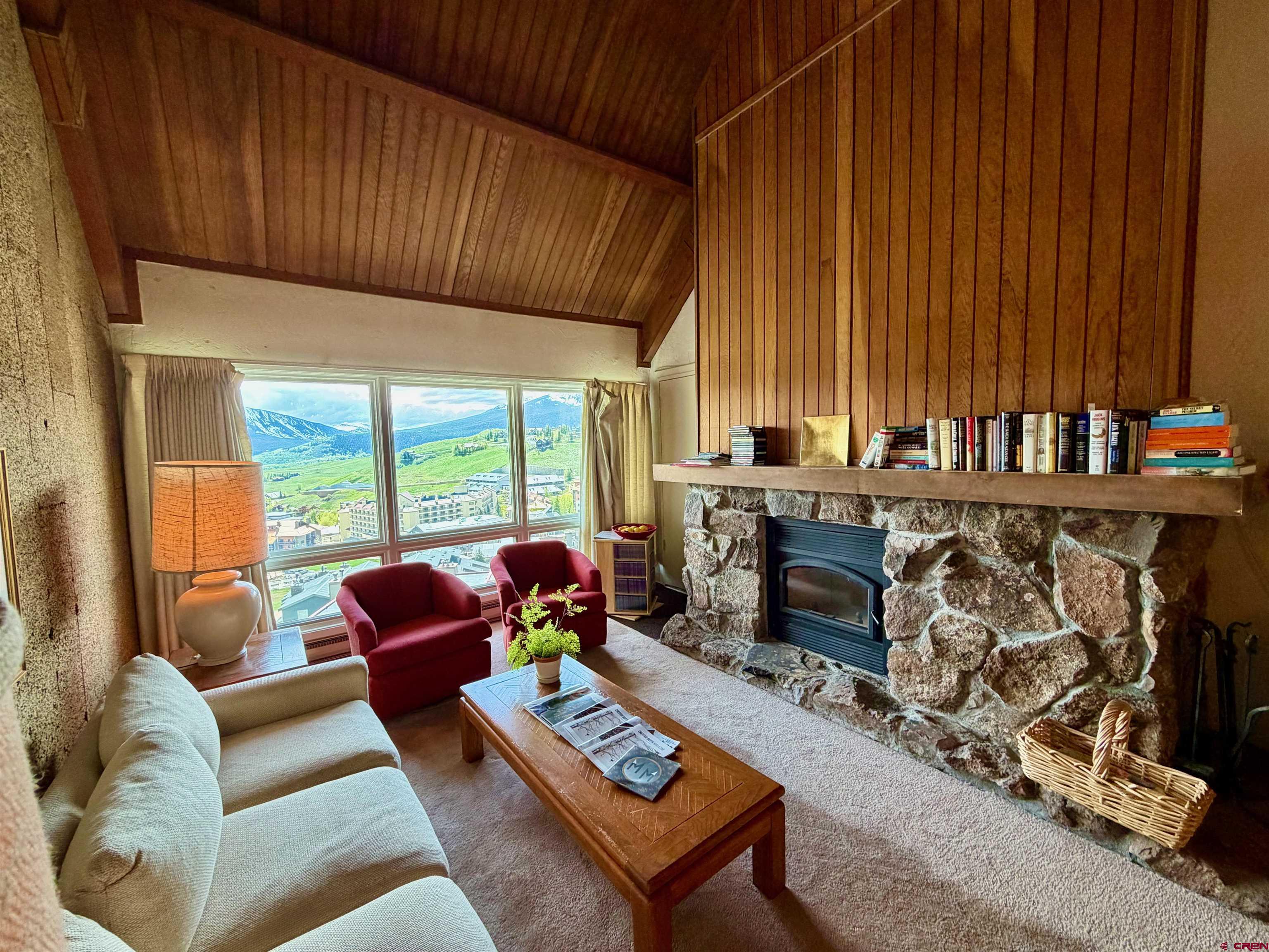 51 Whetstone Road, Unit 2306 Crested Butte, CO 81225 - Photo 6 of 44 a living room with furniture a fireplace and a floor to ceiling window