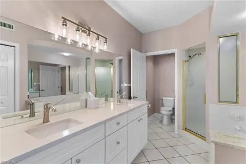 a spacious bathroom with a double vanity sink mirror and toilet