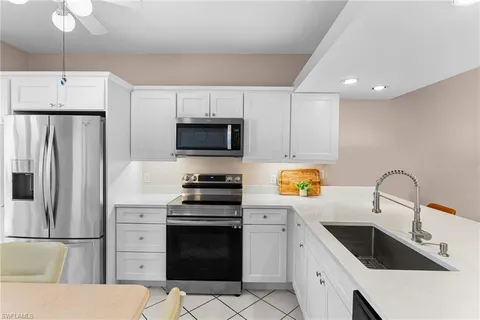 a kitchen with stainless steel appliances a stove a sink a microwave and cabinets