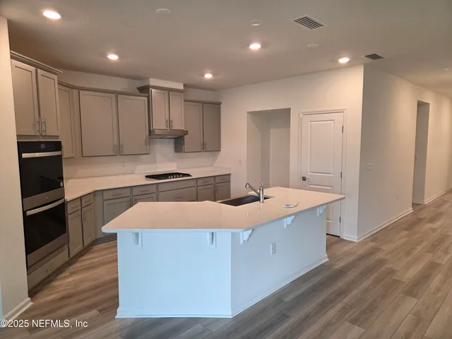 a large kitchen with kitchen island a sink stainless steel appliances and cabinets