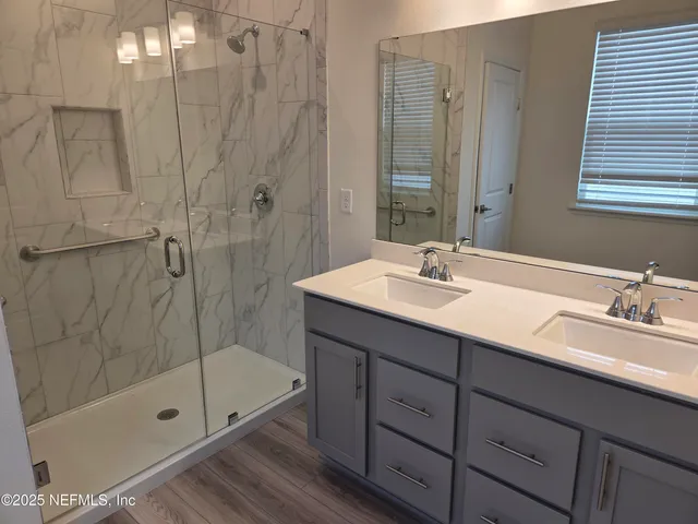a bathroom with a shower sink and mirror