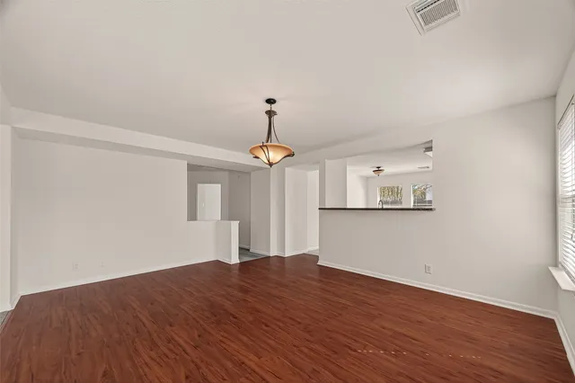 a view of empty room with wooden floor and ceiling fan