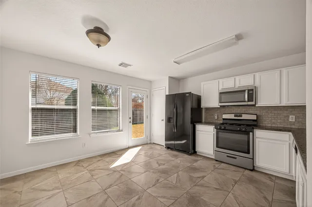 a kitchen with stainless steel appliances granite countertop a refrigerator stove top oven and sink