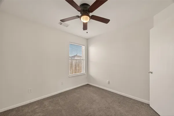 an empty room with a window and a fan