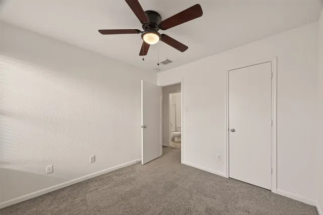 an empty room with a ceiling fan and a ceiling fan