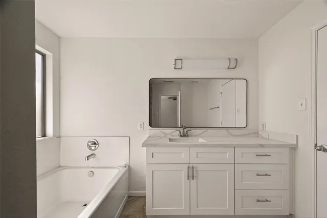 a bathroom with a bathtub sink and mirror