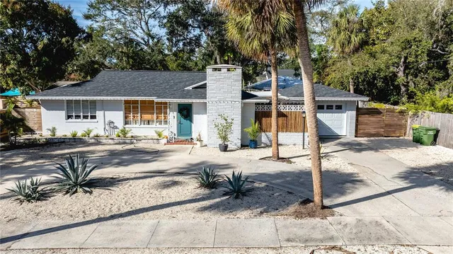 an aerial view of a house with a yard and large trees