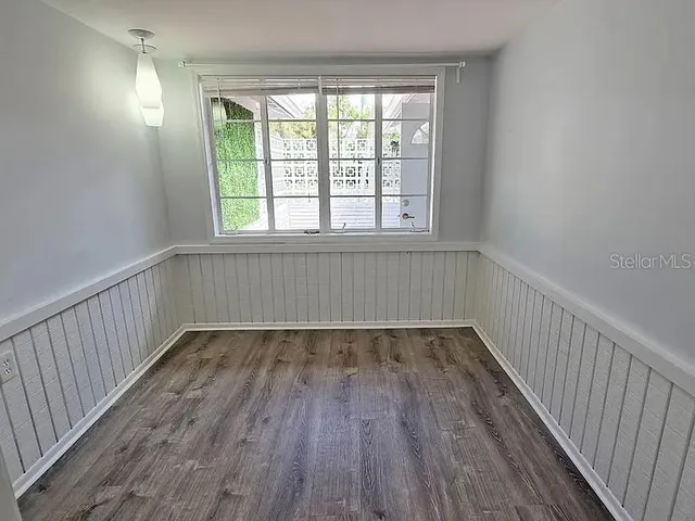 a view of an empty room with wooden floor