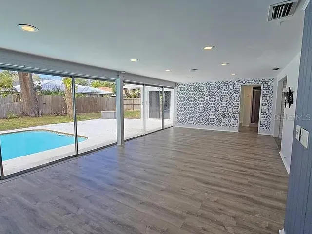 wooden floor in an empty room with a kitchen