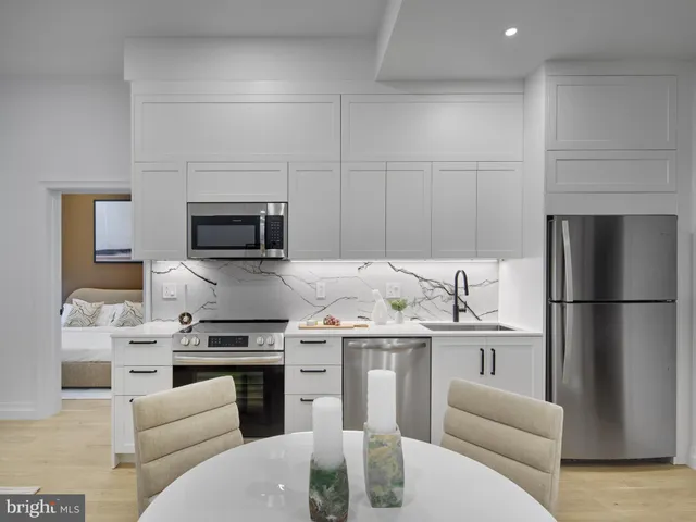 a kitchen with stainless steel appliances a stove a sink and a refrigerator