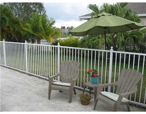 482 Northwest Emilia Way Stuart, FL 34994 - Photo 22 of 25 a view of a chairs and table in the back yard