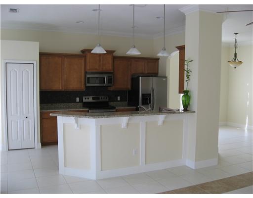 482 Northwest Emilia Way Stuart, FL 34994 - Photo 5 of 25 a kitchen with stainless steel appliances granite countertop a sink a microwave a refrigerator and a stove
