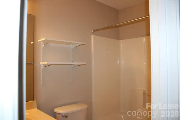a bathroom with a toilet and a shower