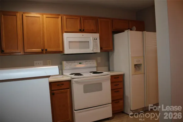 a kitchen with a refrigerator sink and cabinets
