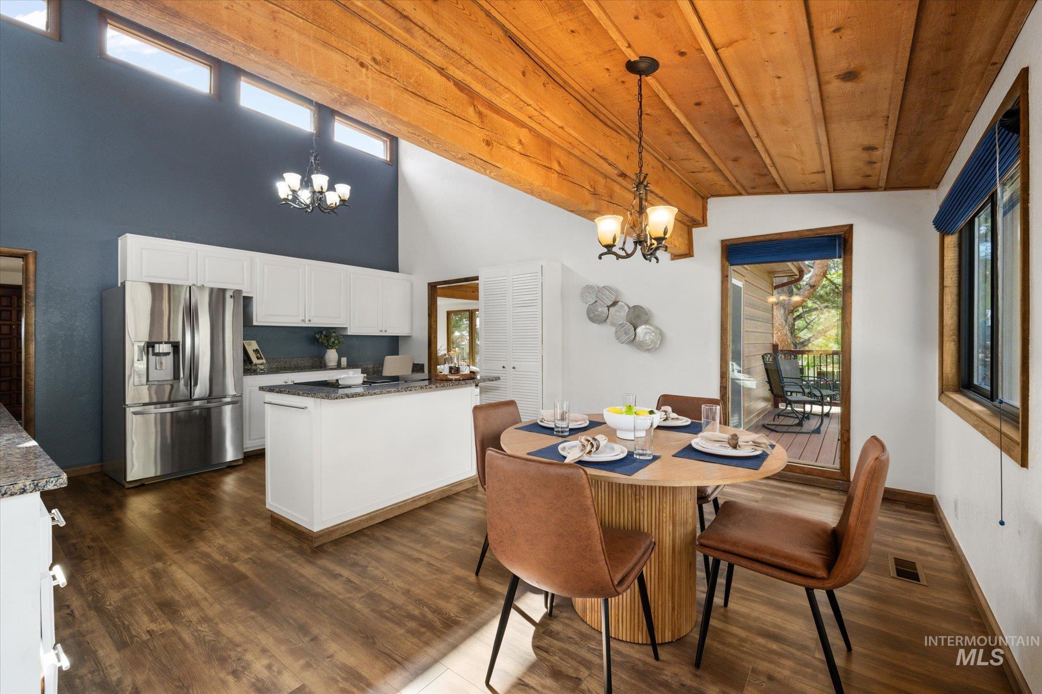 2199 South Ridge Point Way Boise, ID 83712 - Photo 20 of 50 Dining space with healthy amount of natural light, a chandelier, dark wood-style floors, a towering ceiling, and wooden ceiling