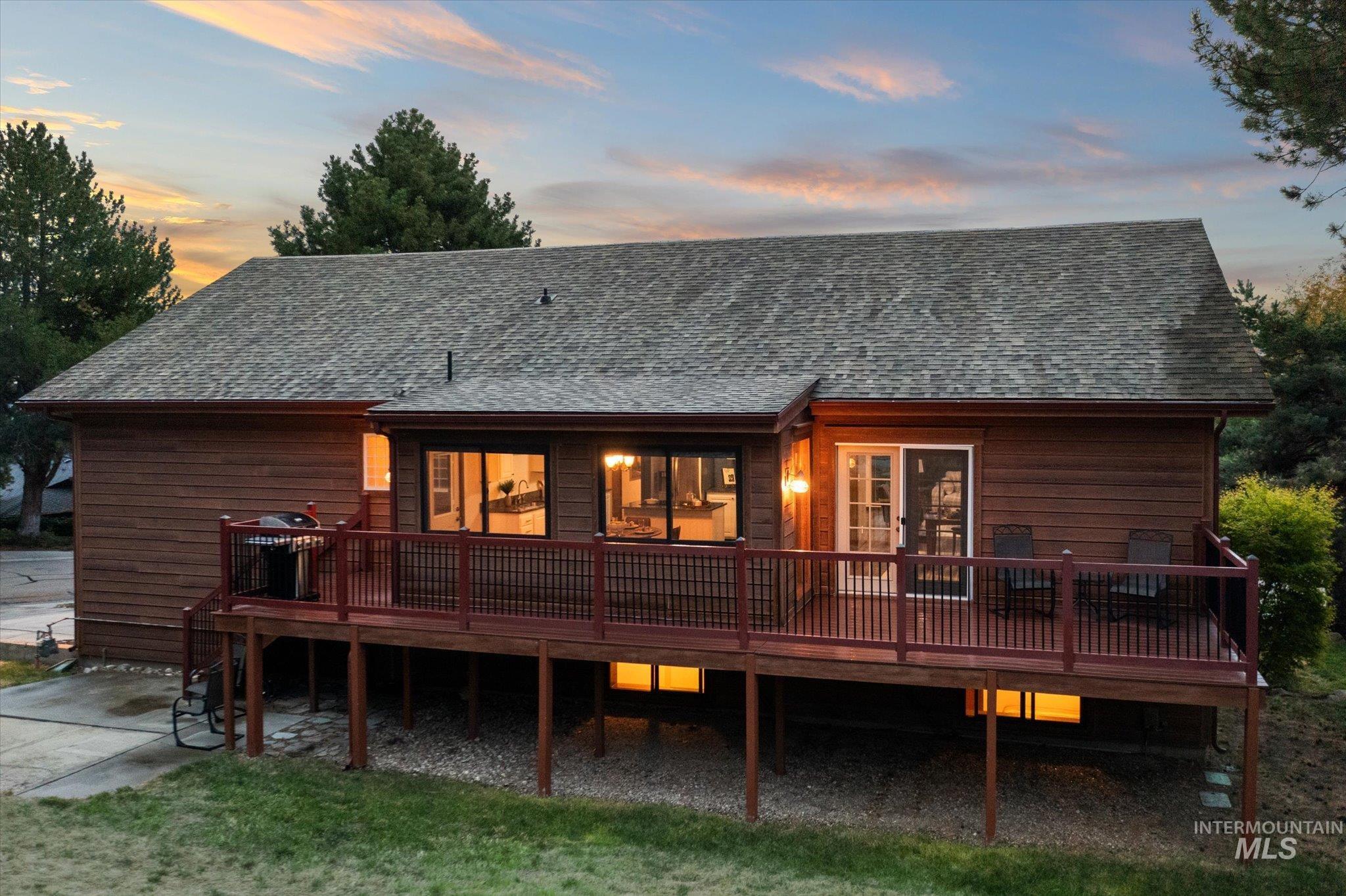 2199 South Ridge Point Way Boise, ID 83712 - Photo 3 of 50 Back of house at dusk with a deck and roof with shingles