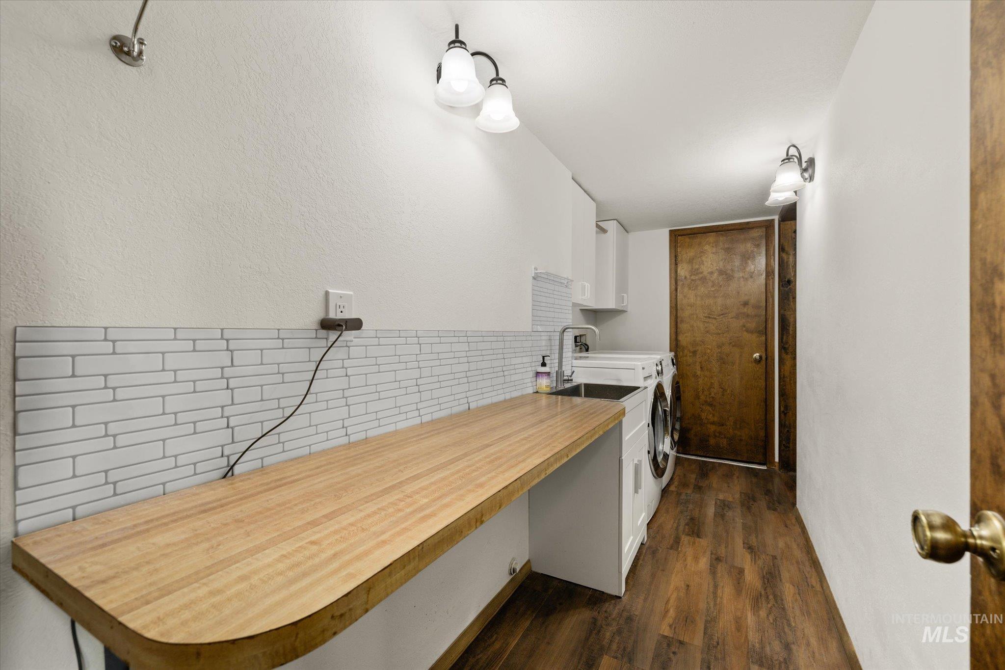2199 South Ridge Point Way Boise, ID 83712 - Photo 38 of 50 Kitchen featuring white cabinets, dark wood-type flooring, light countertops, tasteful backsplash, and a textured wall