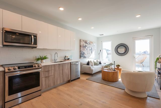 a kitchen with stainless steel appliances granite countertop a stove a sink a microwave a refrigerator and cabinets