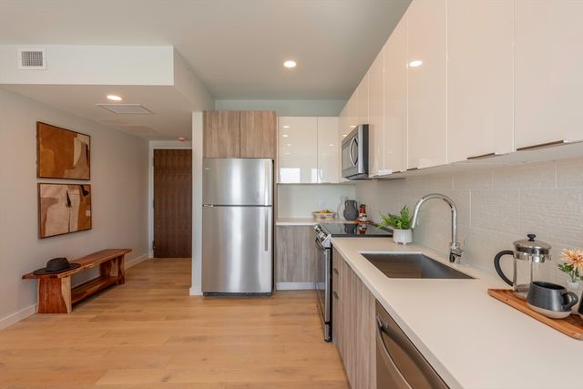 a kitchen with a sink a refrigerator and cabinets