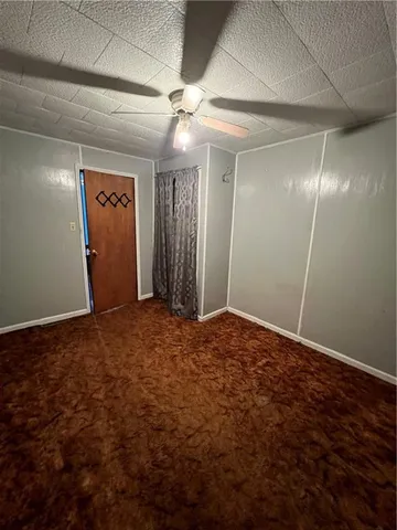 en empty room with windows and fan