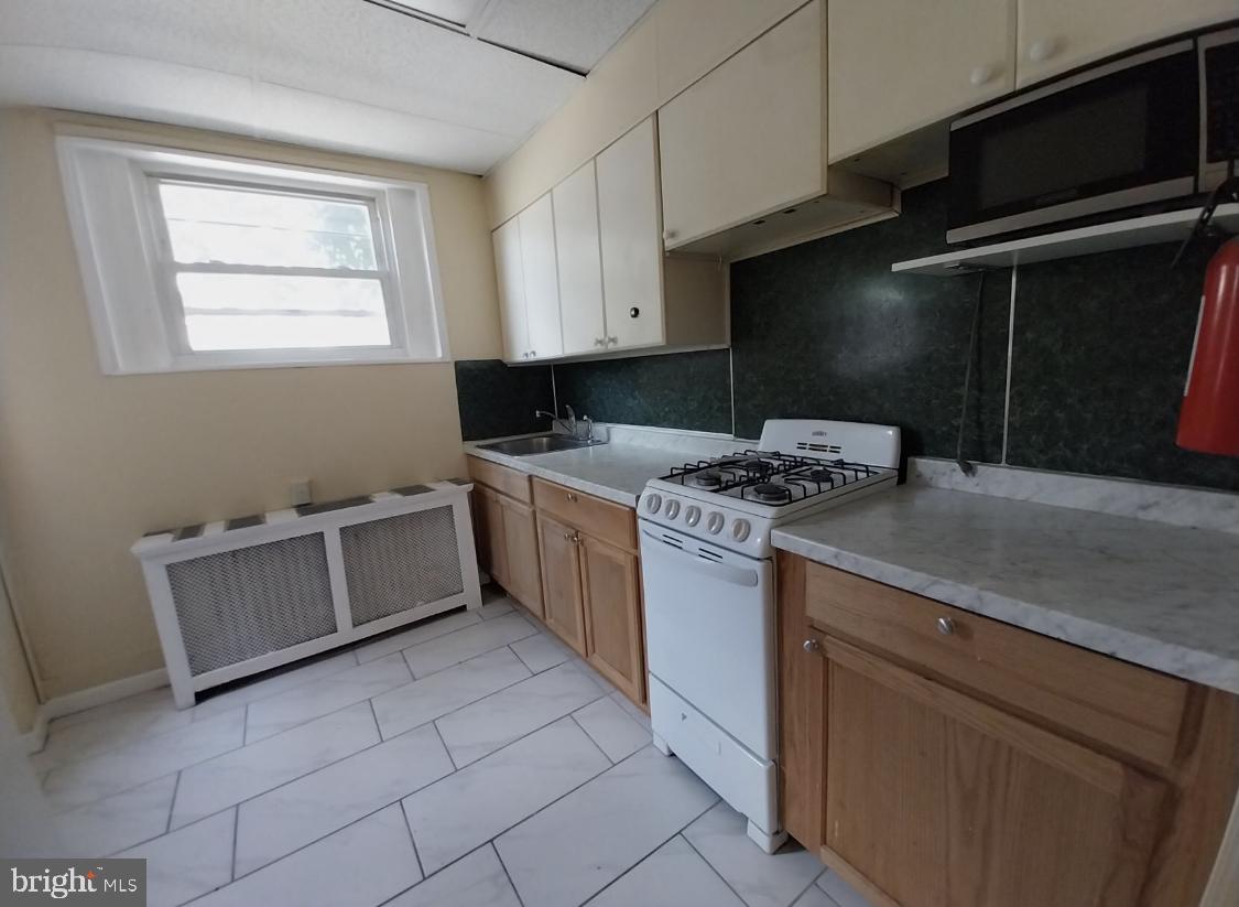 819 Kimball Street Philadelphia, PA 19147 - Photo 6 of 19 a kitchen with granite countertop a sink a stove and cabinets